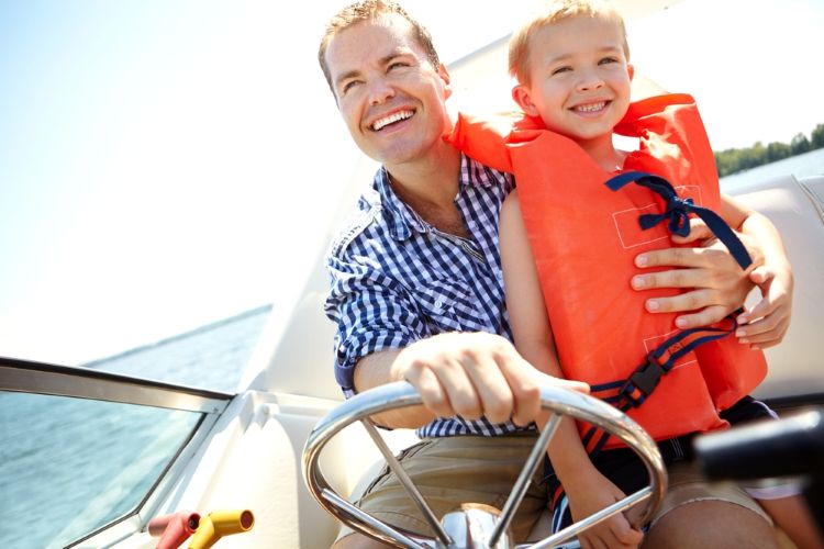 dad and son on a boat